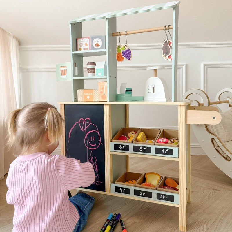 a bold front view of the large green wooden food truck stand fully stocked with play food and accessories