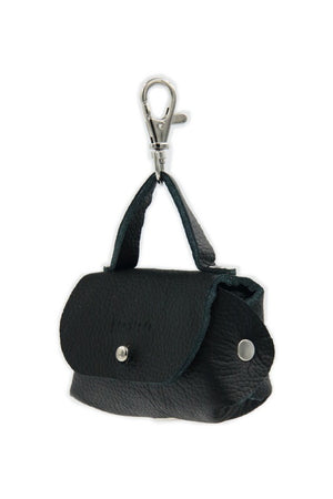 softly lit black leather dog bag dispenser with metal eyelet attached to a leash