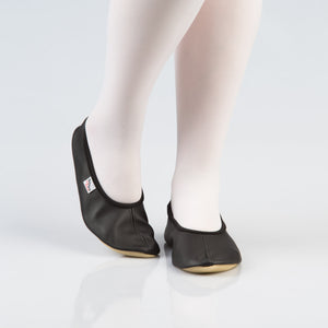 soft black leather gymnastics slippers with a secure rubber edge, resting on a cozy surface