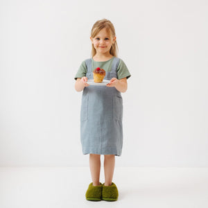 confident child in a blue fog linen pinafore apron, ready for kitchen adventures