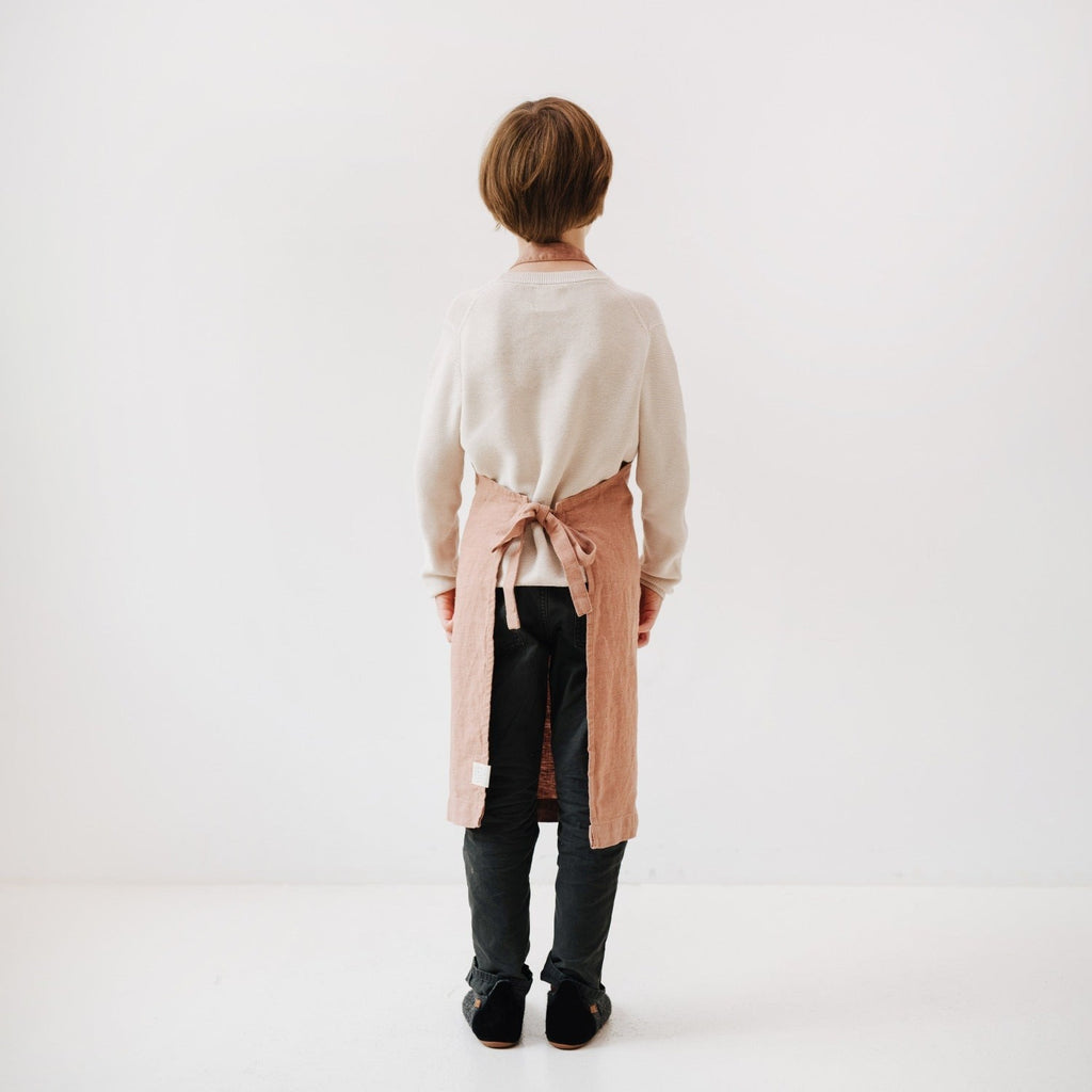 elegant cafe creme linen apron for kids, tied neatly with a front pocket, soft stone-washed texture