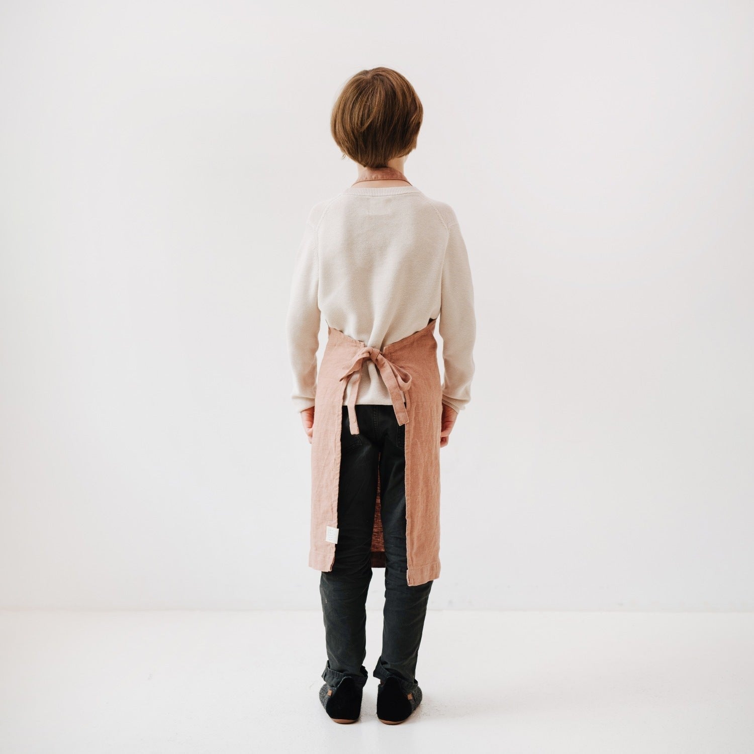 elegant cafe creme linen apron for kids, tied neatly with a front pocket, soft stone-washed texture