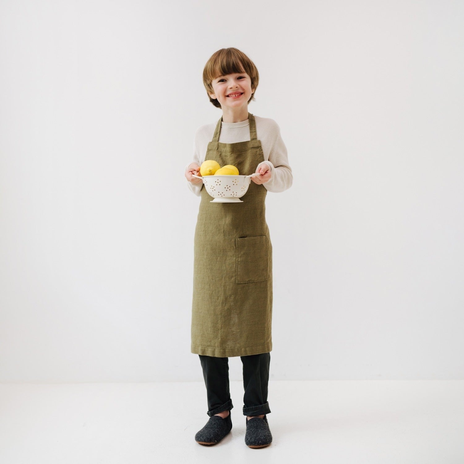 confident little chef in olive linen apron with front pocket, ready for kitchen adventures