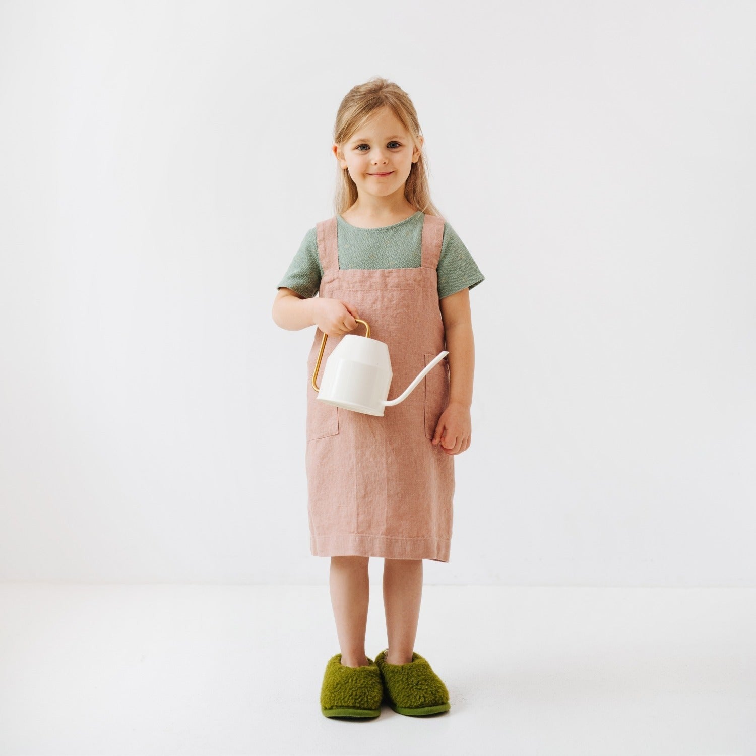 elegant cafe creme linen pinafore apron for kids, handcrafted in lithuania, with two front pockets and no ties