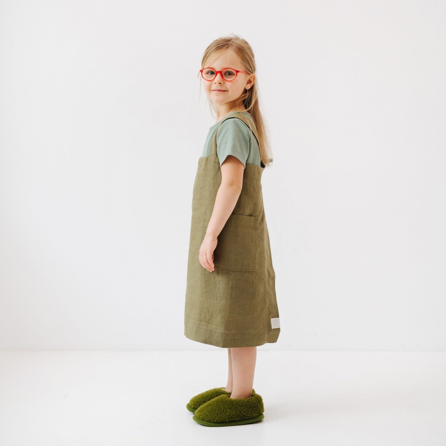 bold olive linen pinafore apron for kids with front pockets, no ties, ready for kitchen adventures