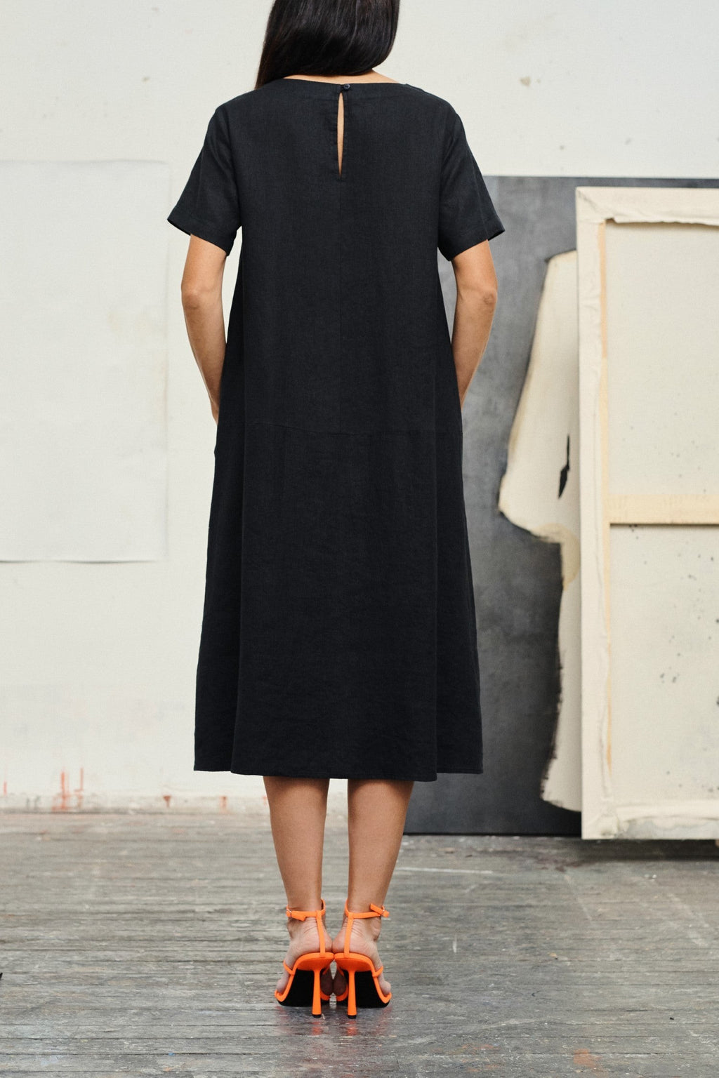 a playful twirl in a black linen dress showing off its a-line fit and front pockets