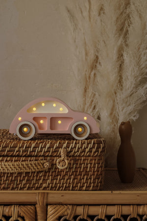 bold hero shot of the pinewood beetle car lamp glowing warmly on a dark wood surface