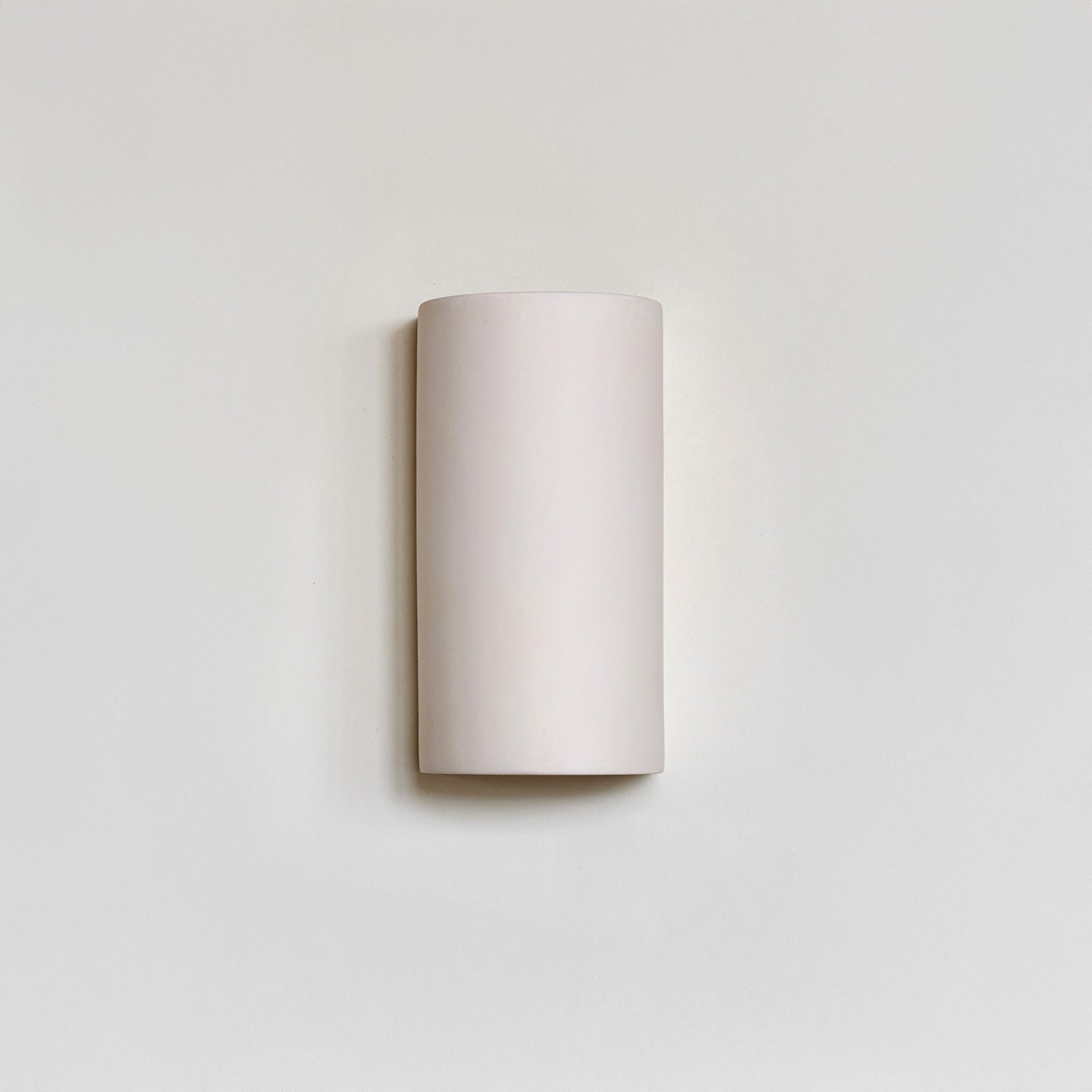 a playful close-up of the matte white sconce casting a fun, dappled glow on a nursery wall