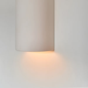 a softly glowing white ceramic wall sconce casting a warm, comforting glow in a nursery