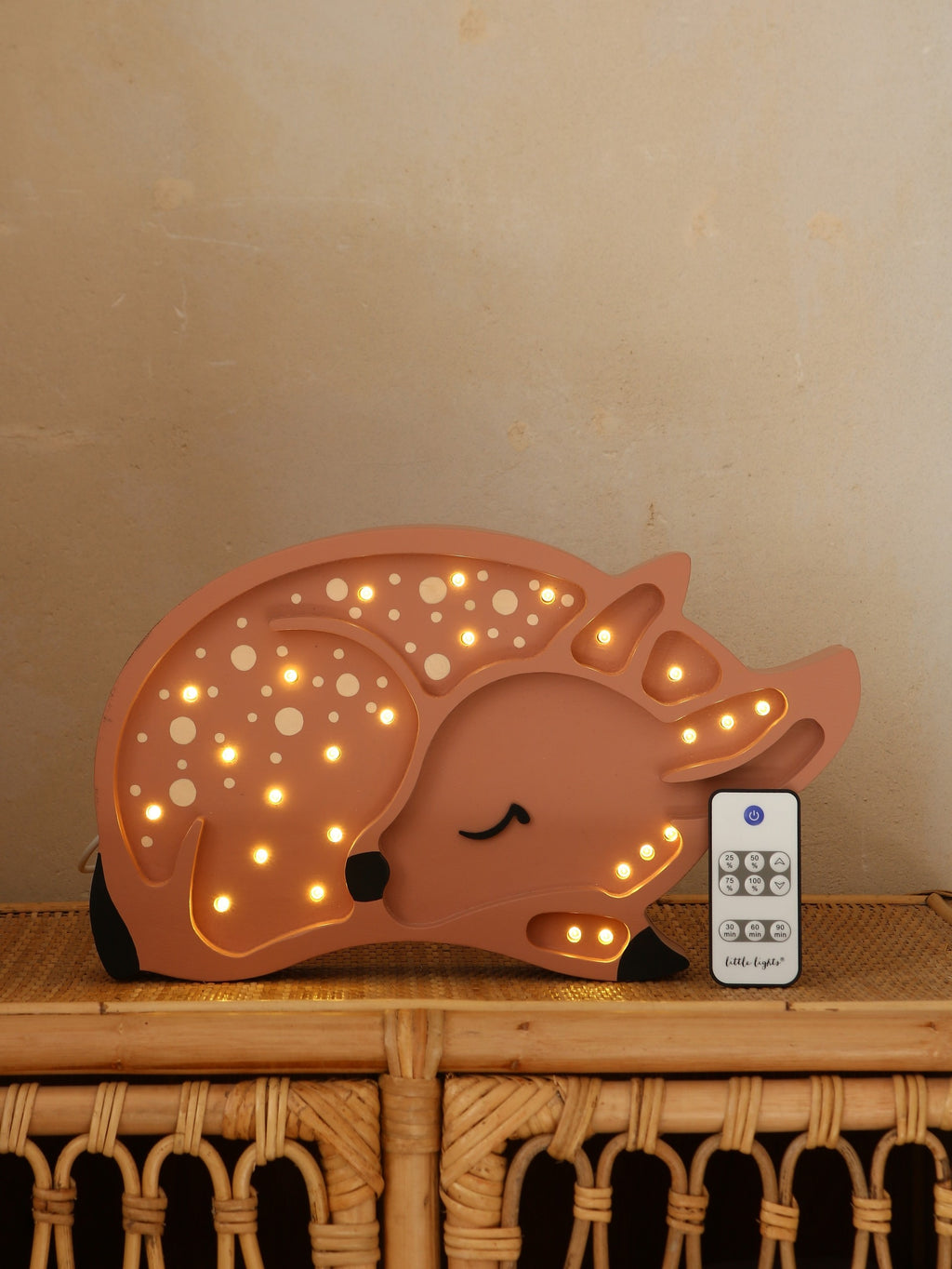 bold artisan deer lamp casting a warm glow on a modern nursery shelf