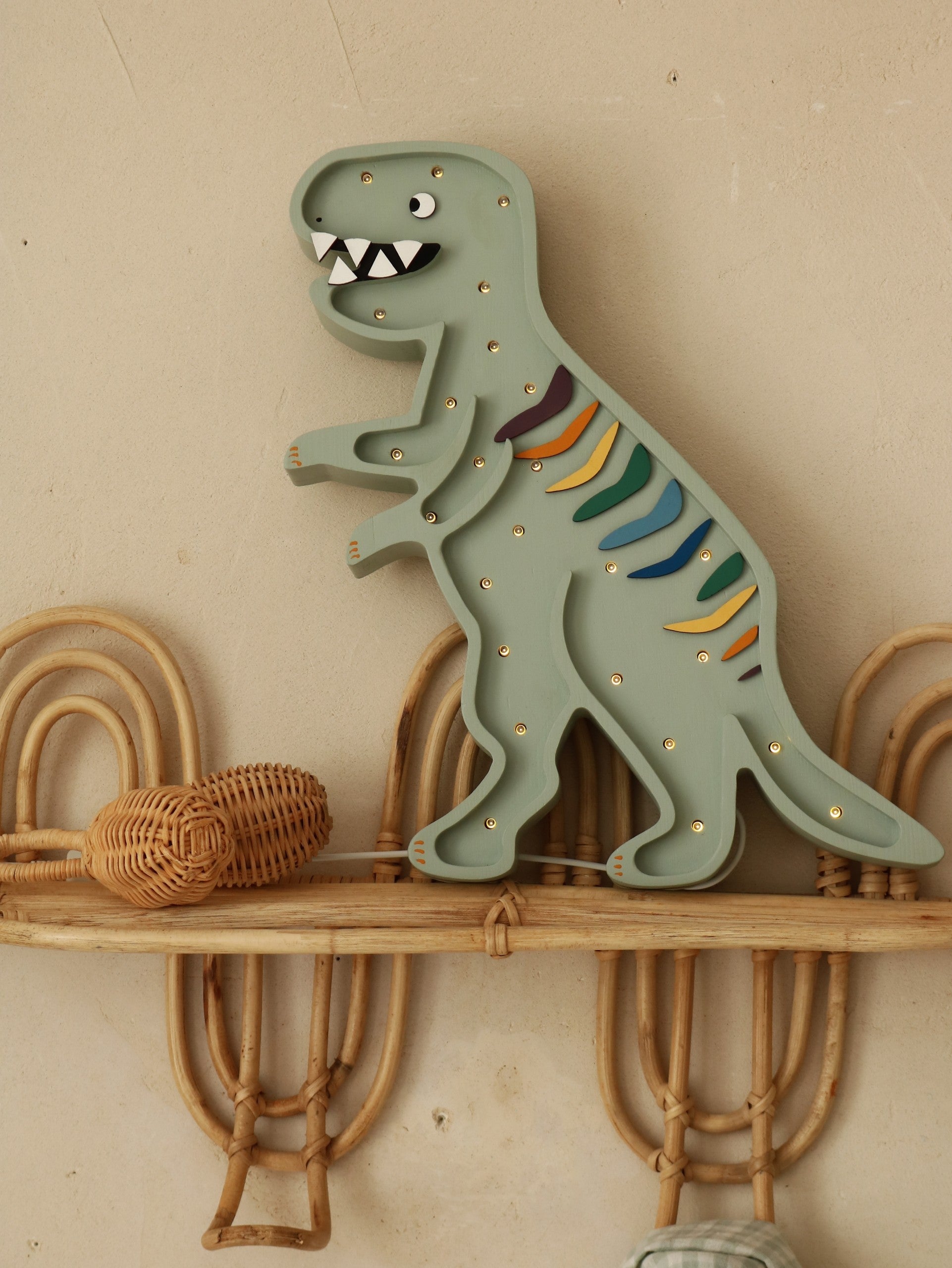 handcrafted t-rex lamp casting a warm glow on a childs bedside table