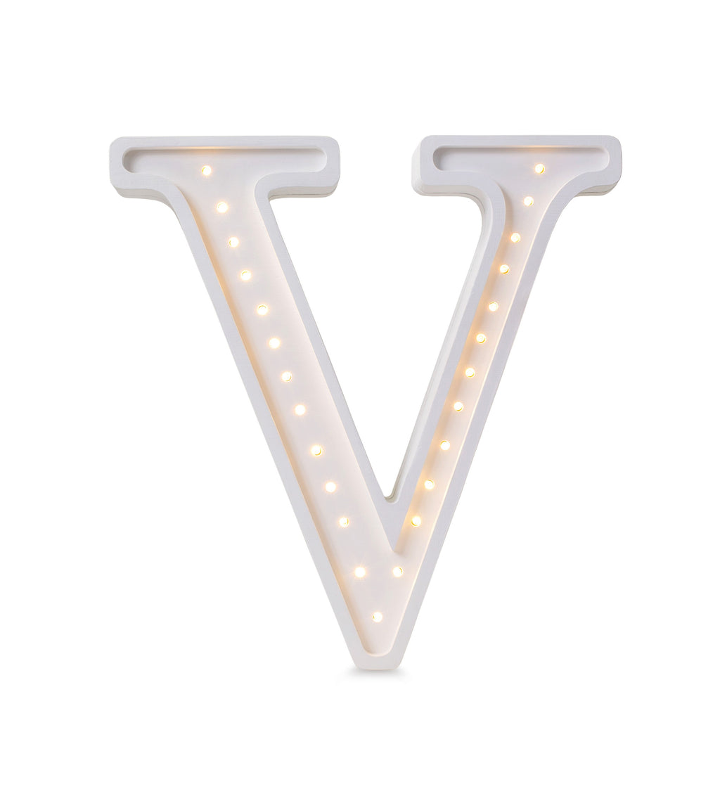 softly glowing letter v lamp casting a warm cozy light on a pinewood nightstand