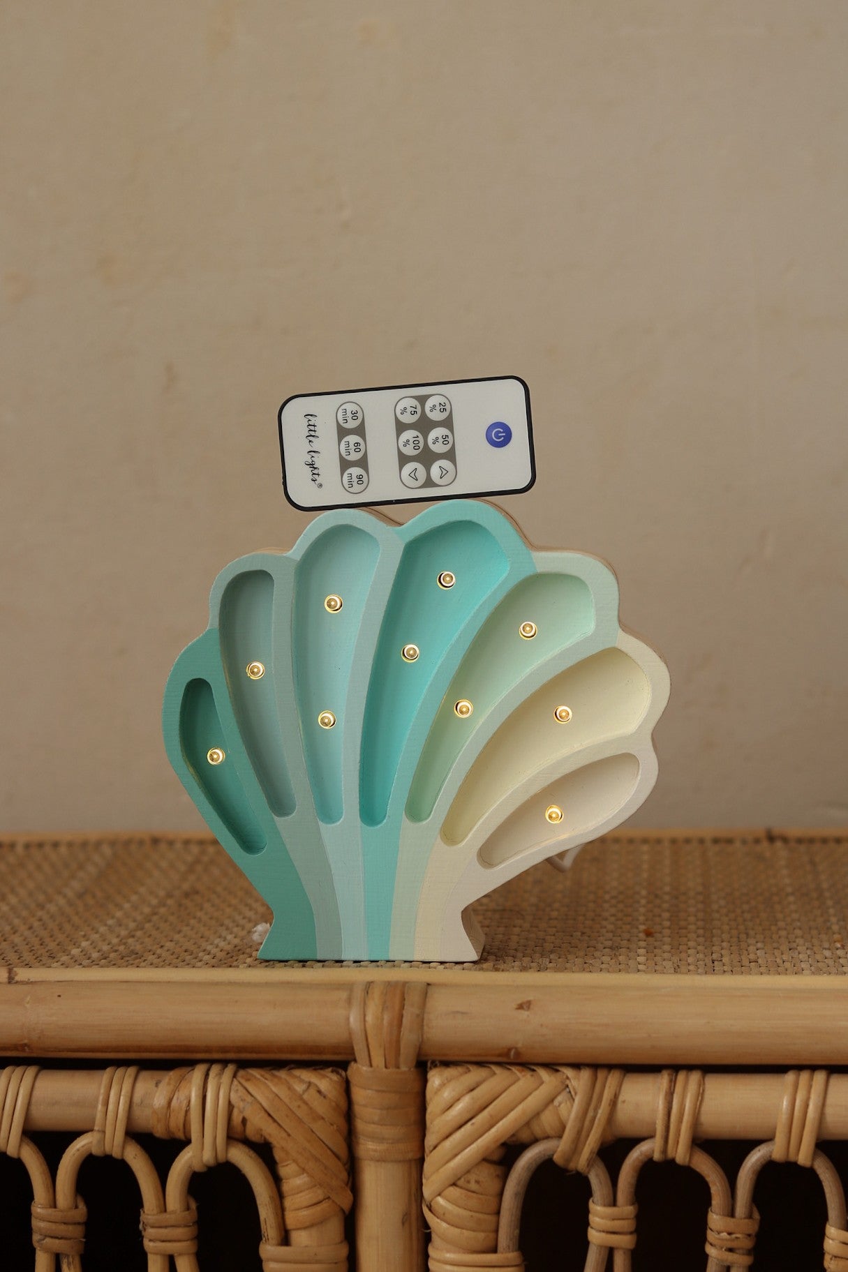 handmade pine wood seashell lamp casting a soft, warm glow on a childs bedside table