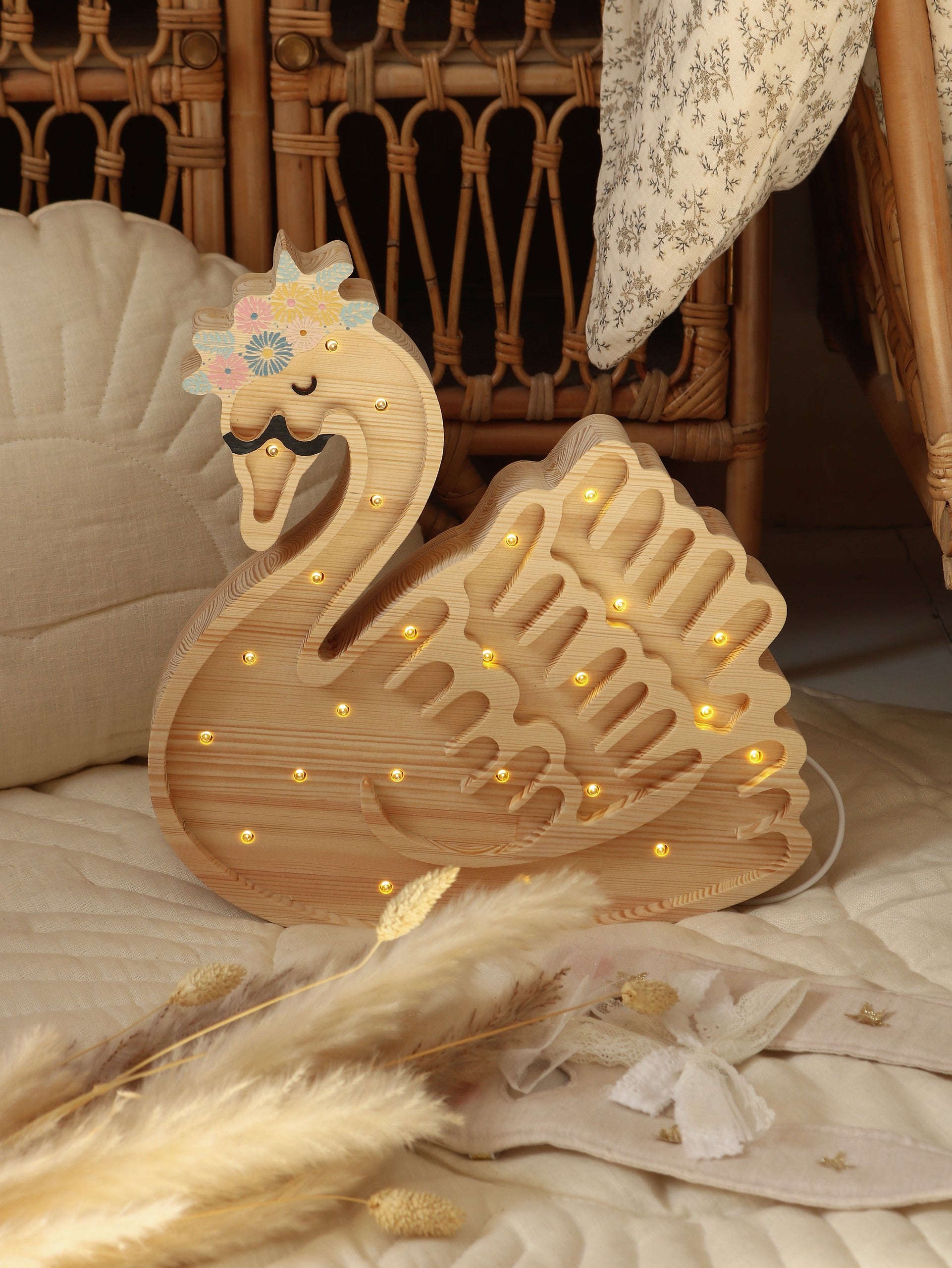 bold close-up of a handcrafted pine wood swan lamp illuminating a child's room