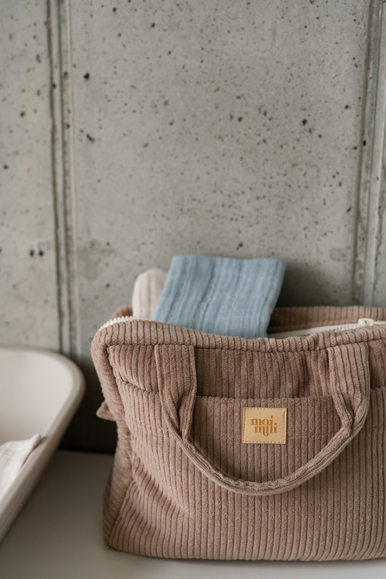 moi mili latte makeup bag set of two on a rustic wooden table with morning light