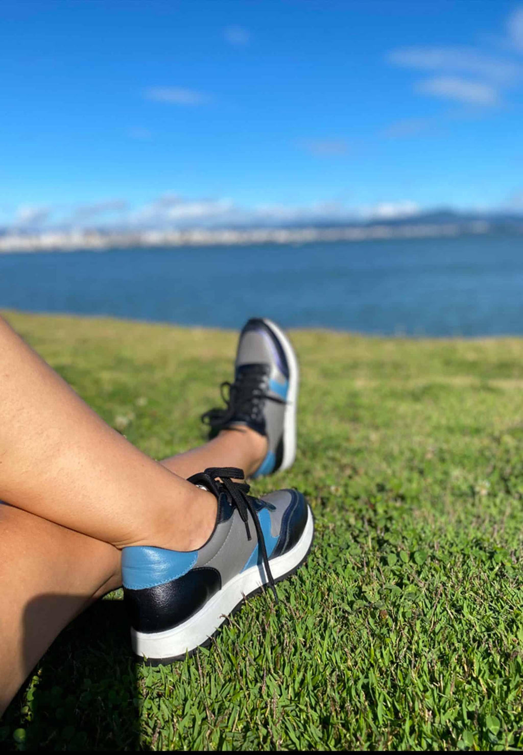 mangara buriri women's leather sneaker side profile on a city sidewalk, showcasing its durable rubber sole and practical low-top design