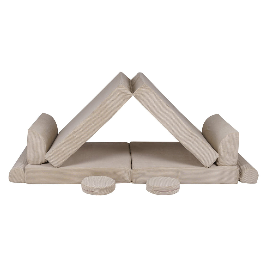 a playful child's ecru corduroy sofa with two poufs in a sunlit playroom corner