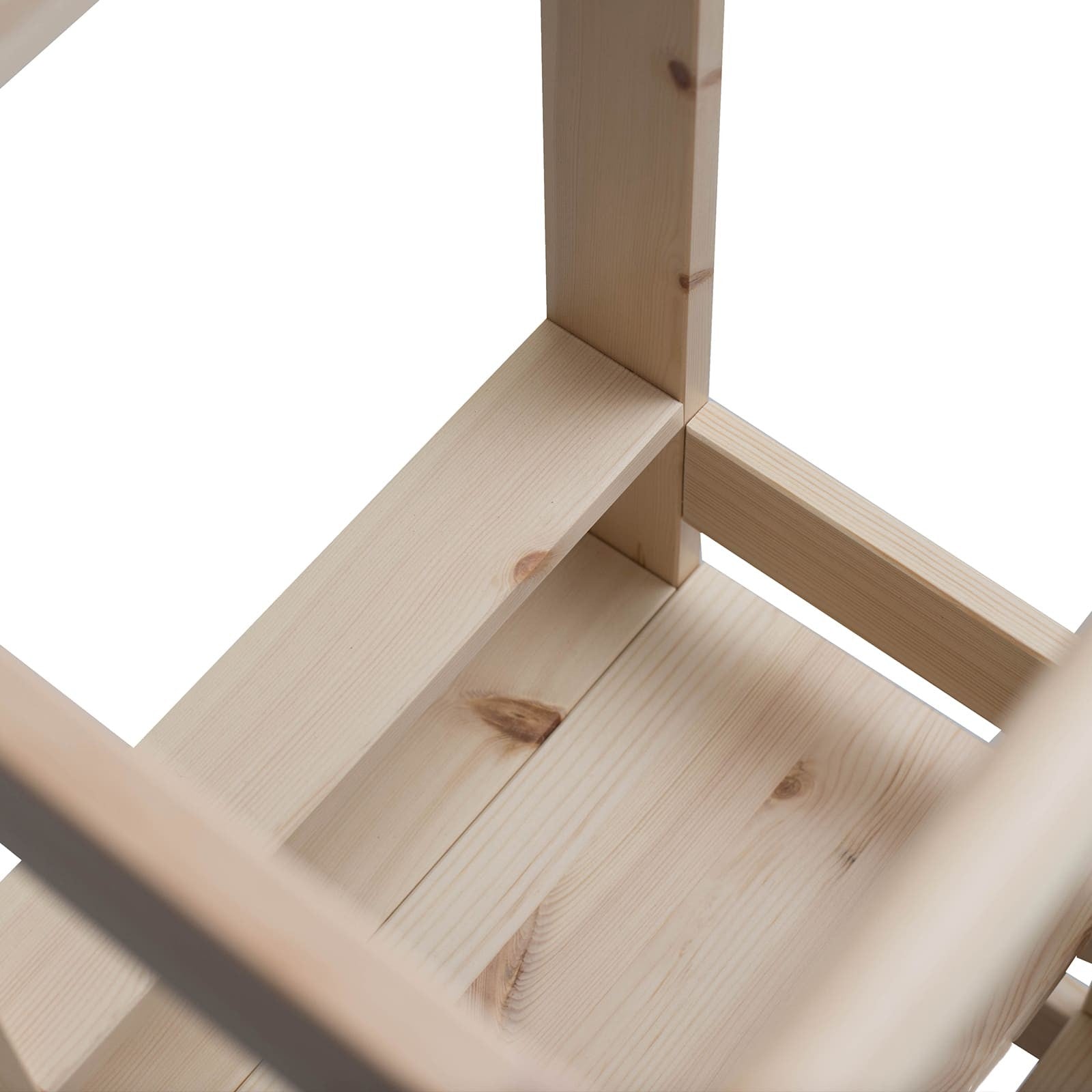 a child using the natural wood kitchen helper stool to reach the counter and help with baking