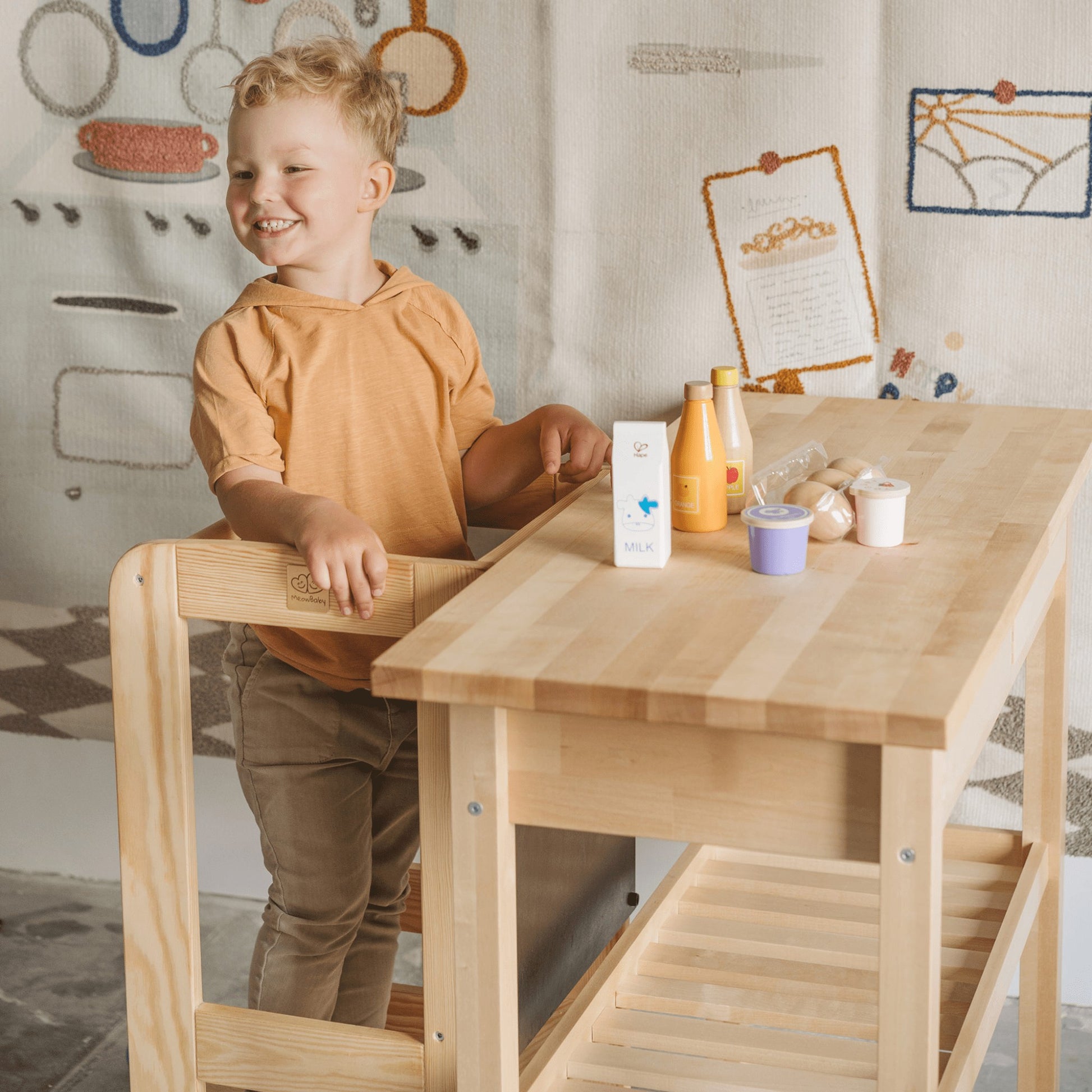 child's-eye view of a toddler safely mixing batter on the meowbaby wooden kitchen helper stool