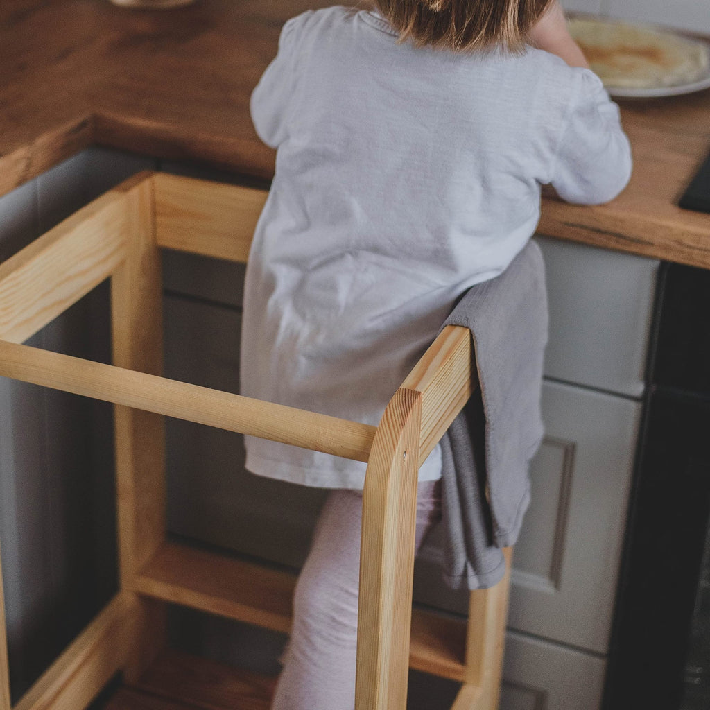 meowbaby kitchen helper stool in a warm, sunlit kitchen with a child helping bake cookies