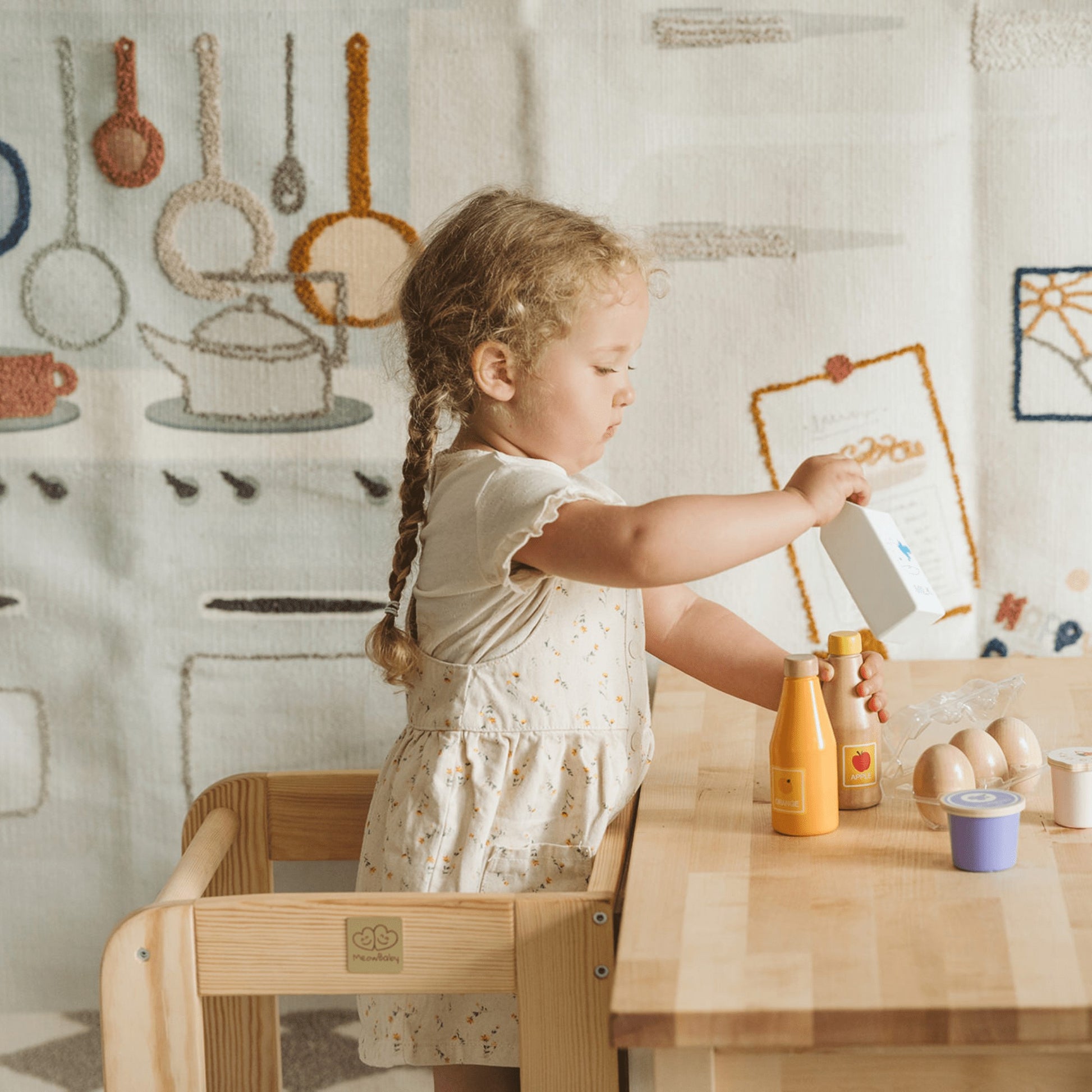 a child safely reaching the counter with the natural wooden meowbaby kitchen helper stool