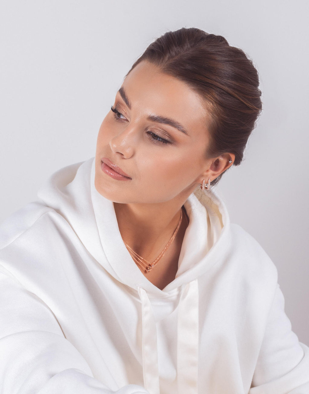 softly lit sterling silver hoop earrings with white zircons resting on a textured surface