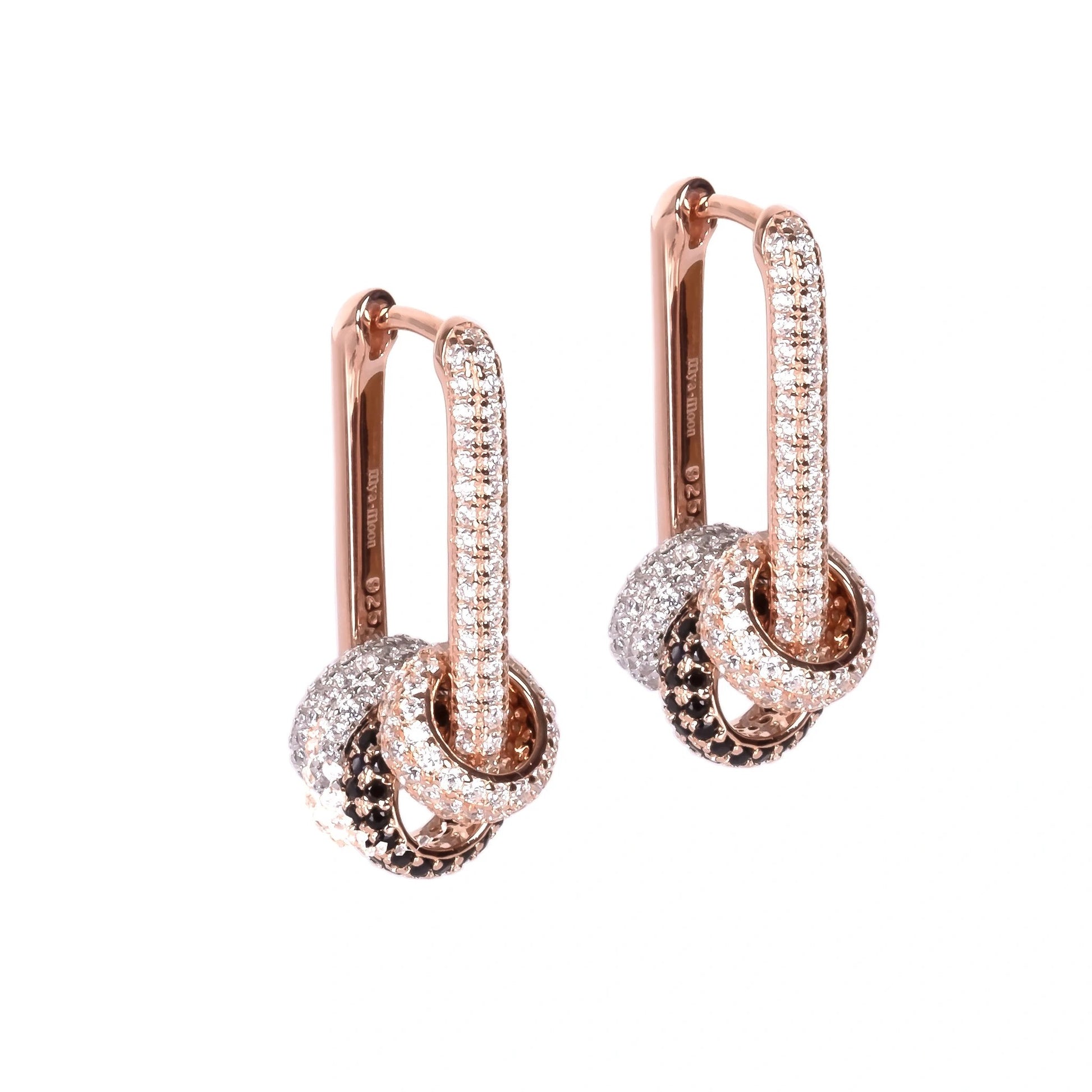softly lit convertible hoop earrings with white zircons resting on a cozy leather background