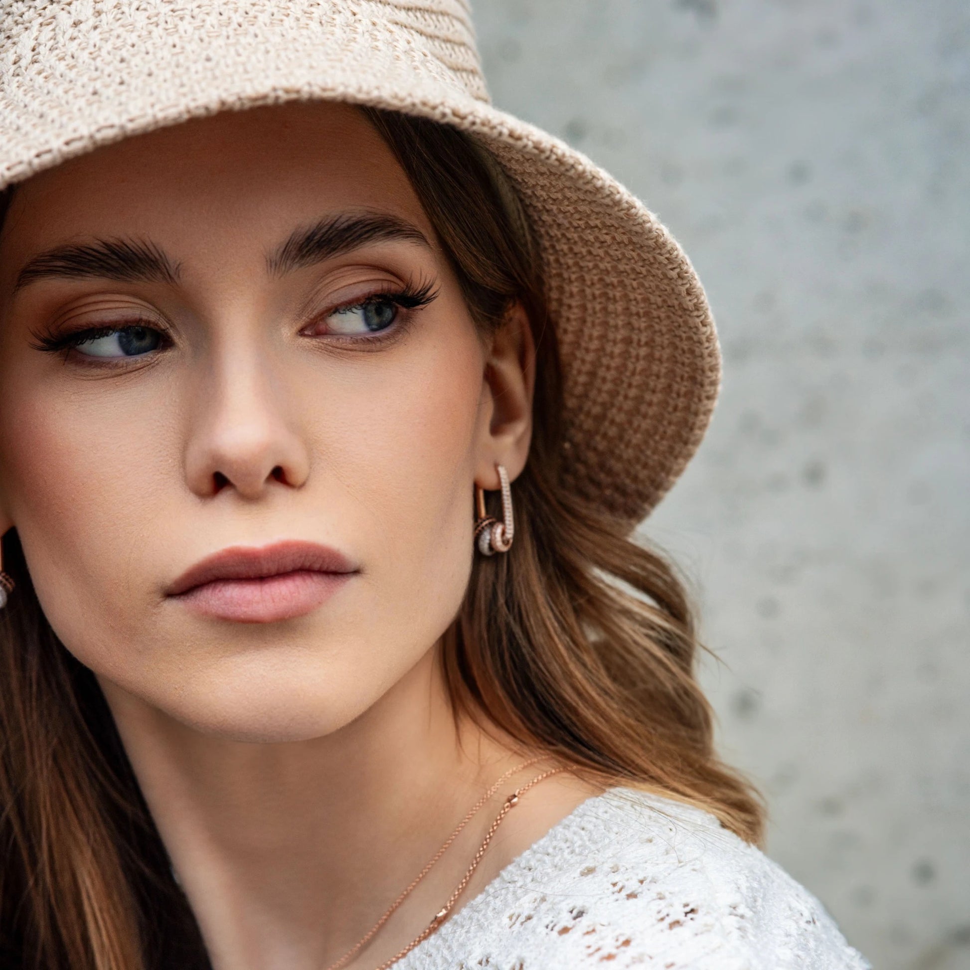 playful close-up of convertible hoop earrings with white zircons sparkling against a vibrant background