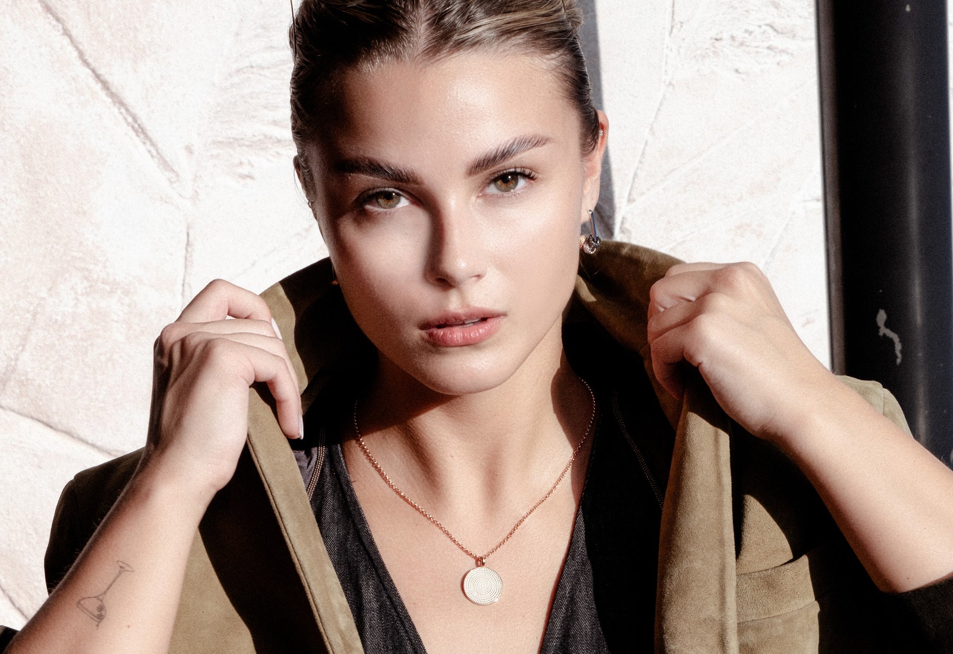 softly lit sterling silver hoop earrings with detachable city charms on a cozy knit background