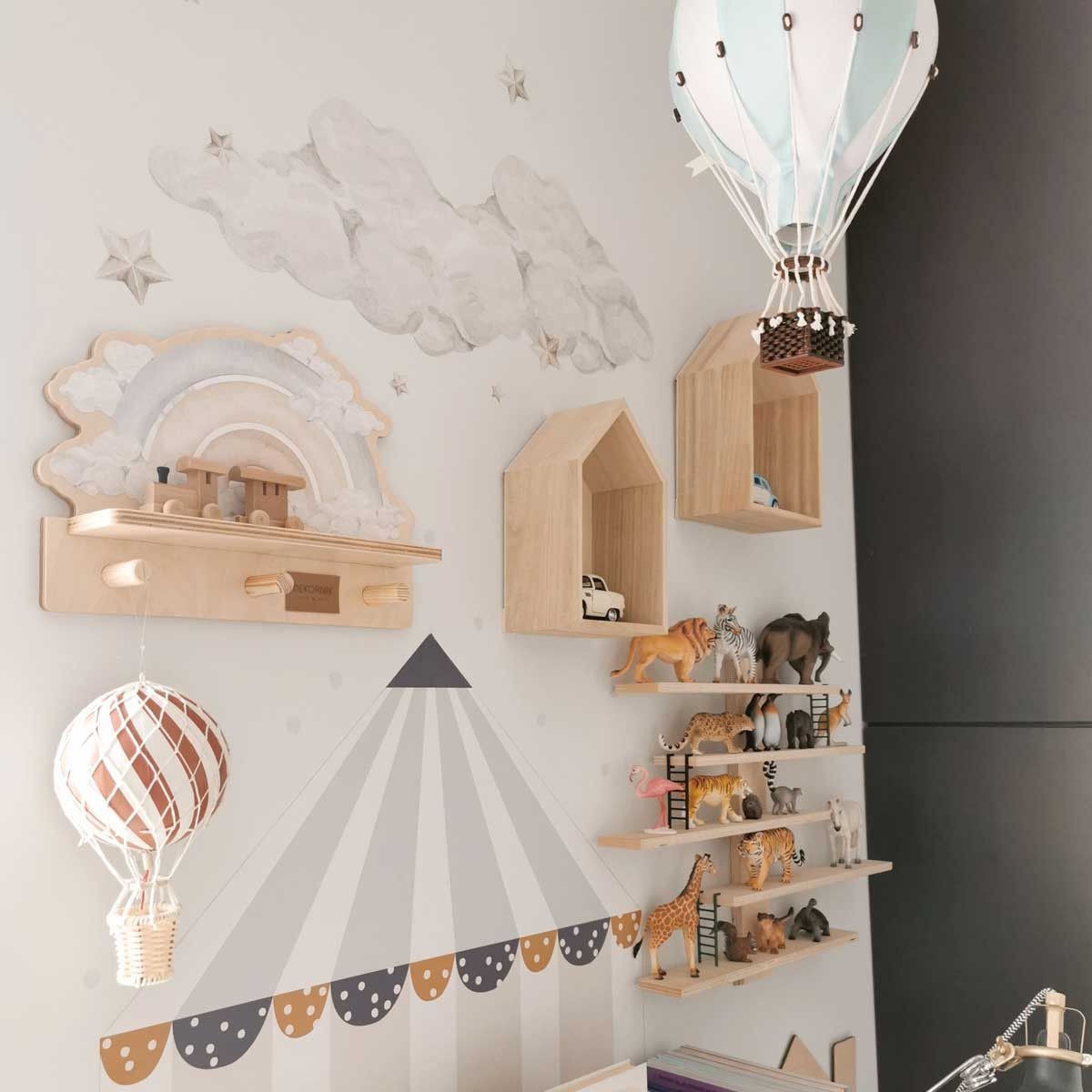blue rainbow wall shelf mounted above a desk holding a small plant and keys on its pegs