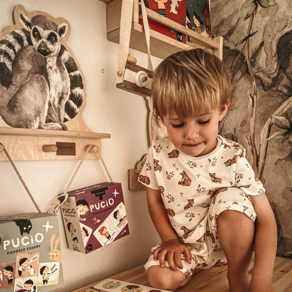 a soft-lit view of the lemur wall shelf with a plush toy resting on it, creating a cozy nursery vibe