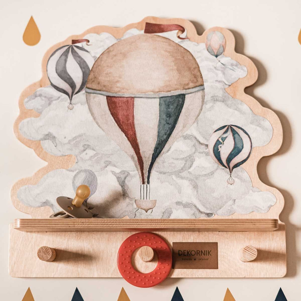 a soft-lit view of the pastel balloon wall shelf mounted in a cozy nursery