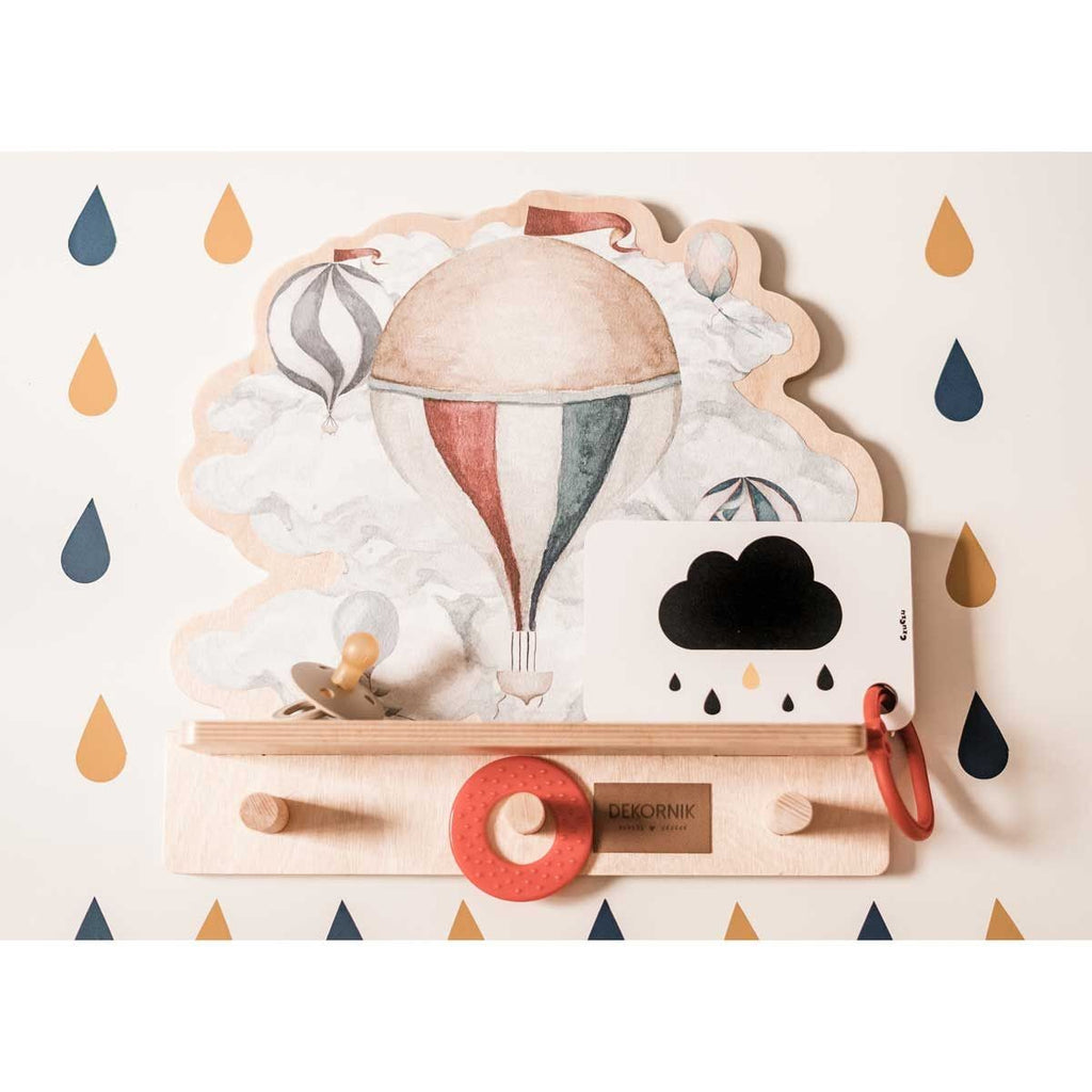 a playful dinosaur wall shelf with a bright balloon sticker, seen from a low angle in a sunlit kids room