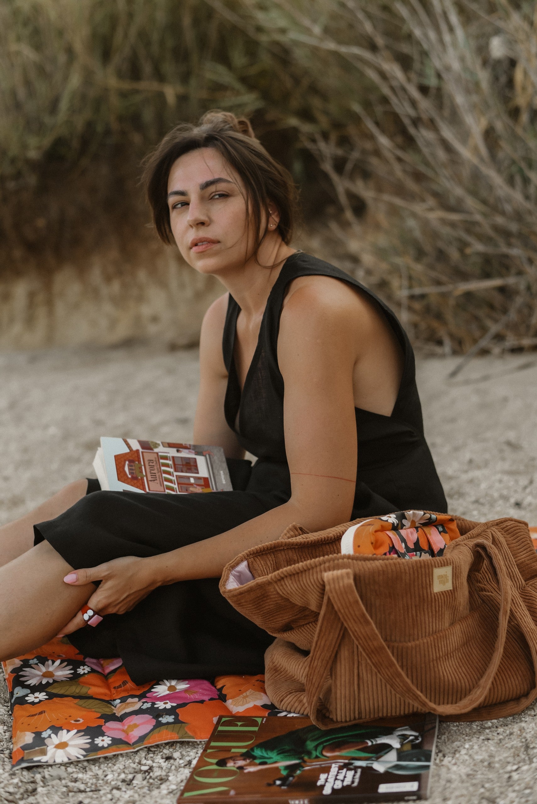 elegant caramel weekender bag with velvet texture, open to show inner pockets, resting on a wooden bench