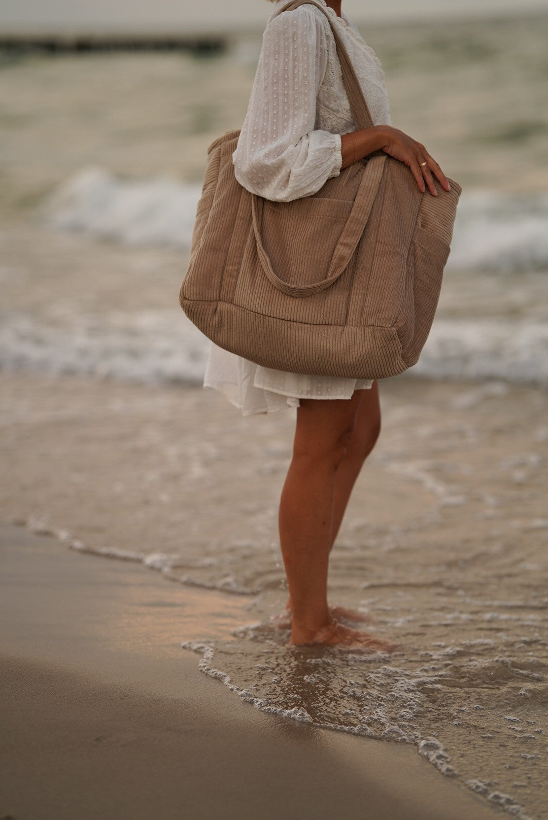 elegant latte weekender bag with velvet texture, open to show inner pockets and waterproof lining