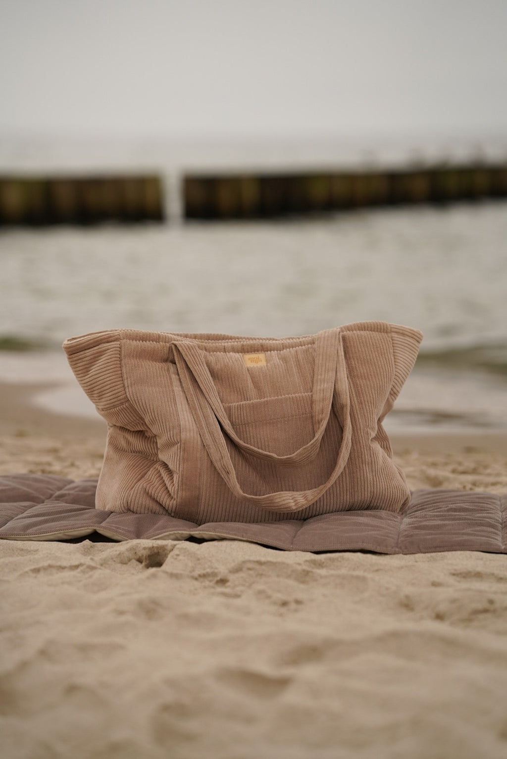 latte-colored mom weekender bag with velvet texture, open to show inner pockets and waterproof lining