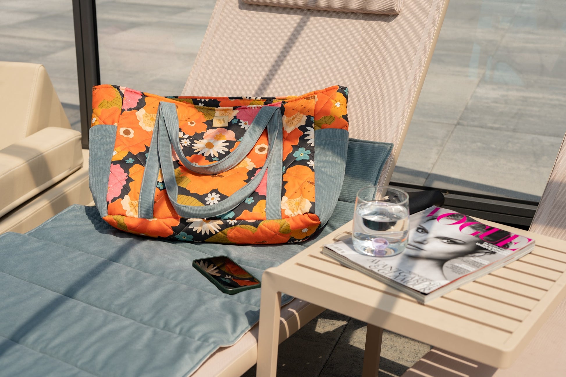 elegant floral weekender bag in soft velvet with gold zipper, open to show inner pockets, on marble table