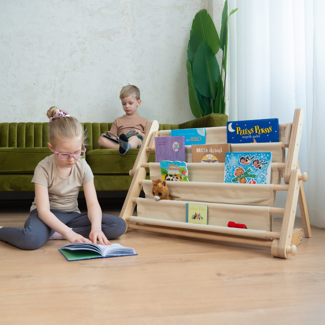 bold front-facing montessori bookshelf attached to a play frame with vibrant book covers