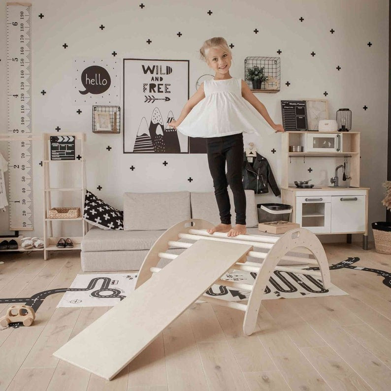 soft-lit montessori climbing arch with ramp, inviting toddlers to explore balance and play in a cozy nursery