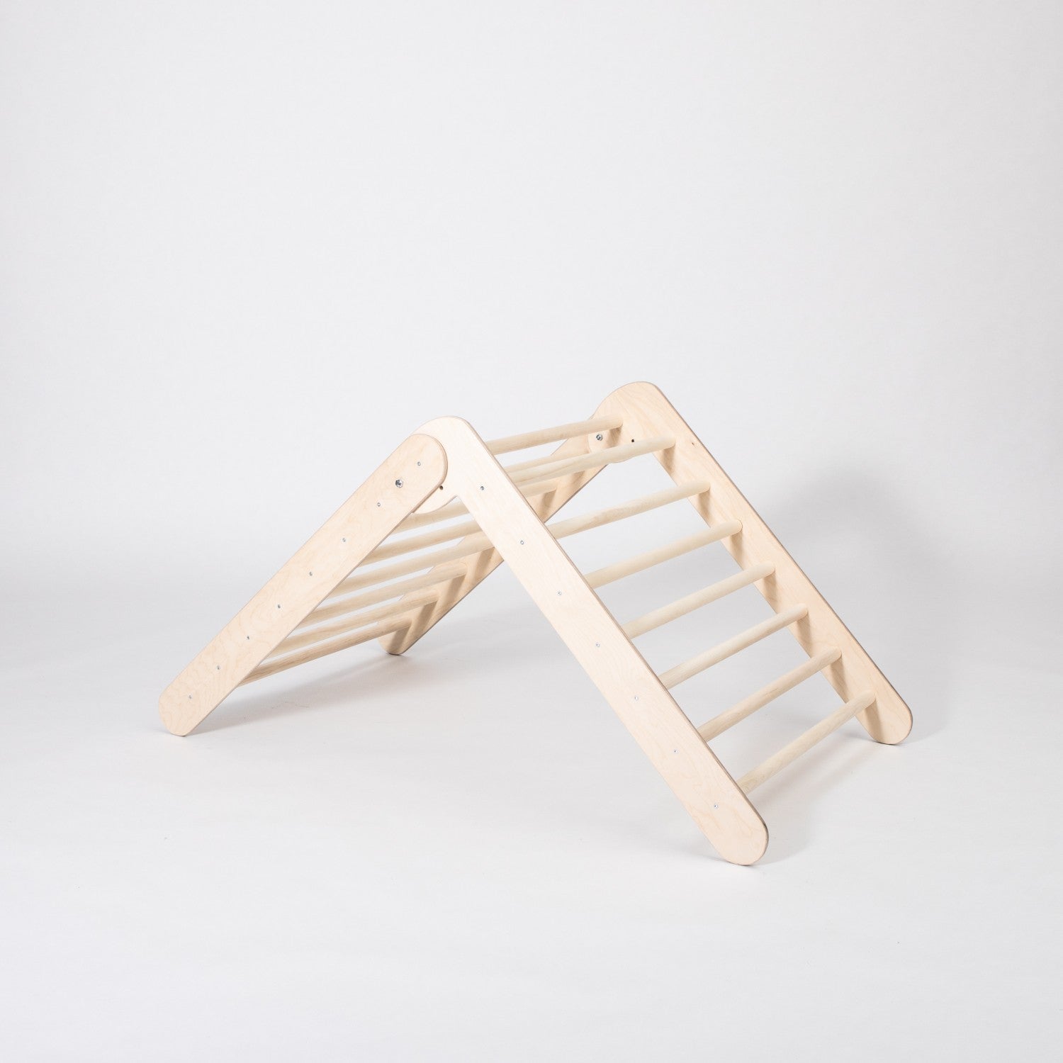 montessori climbing triangle with eight rings per side, folded for storage in a cozy home setting