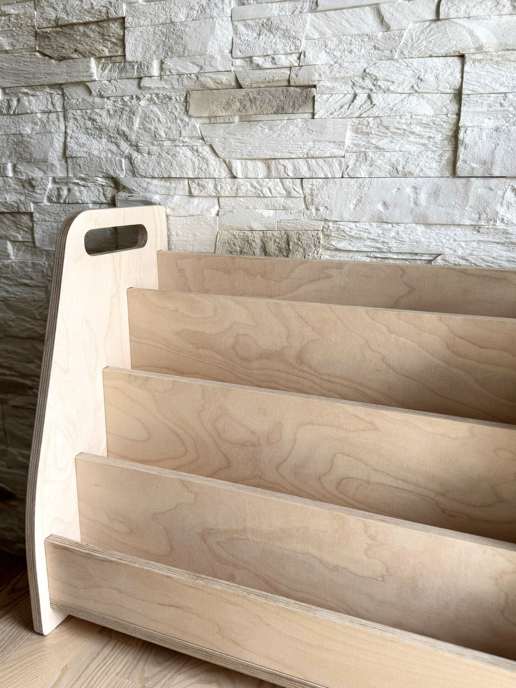 elegant birch plywood book stand displaying children's books in a refined, minimalist home library nook