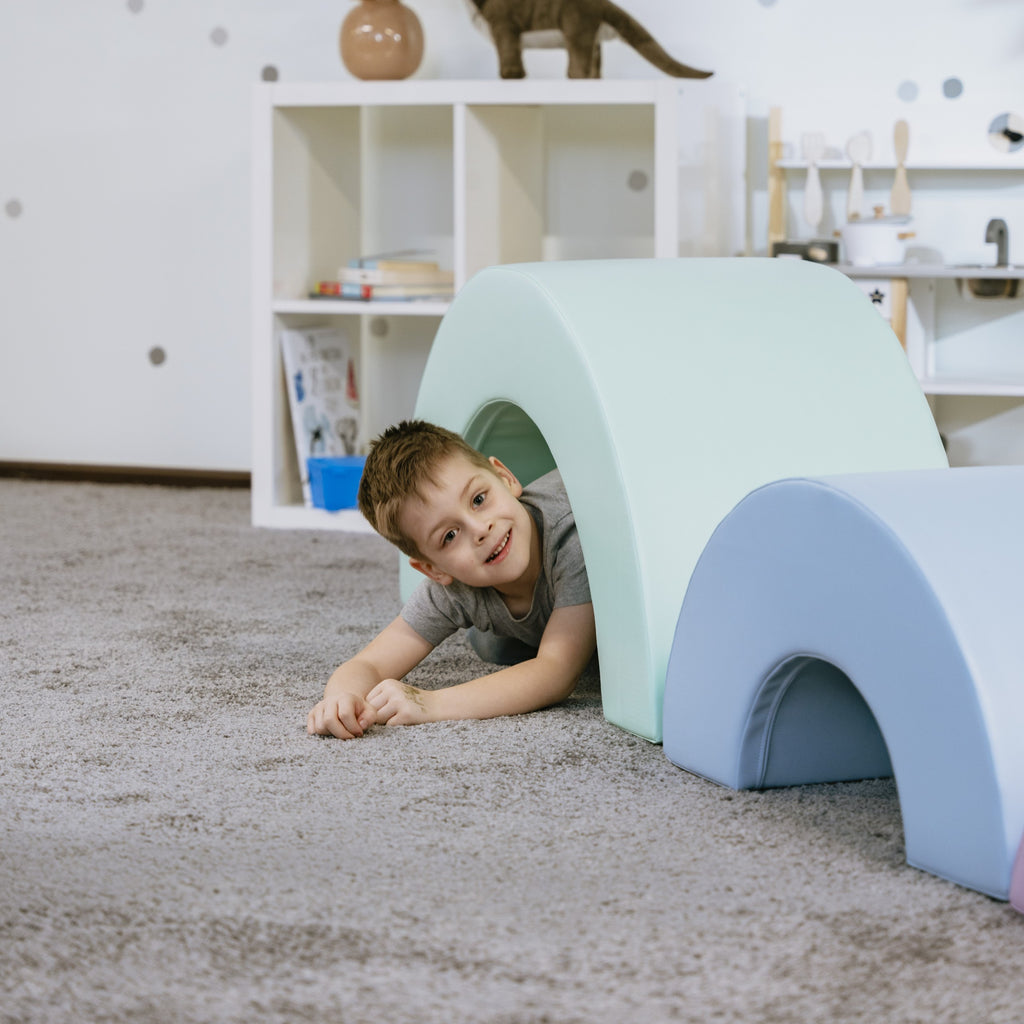a toddler's hands stacking vibrant montessori rainbow blocks in a playful sunlit room