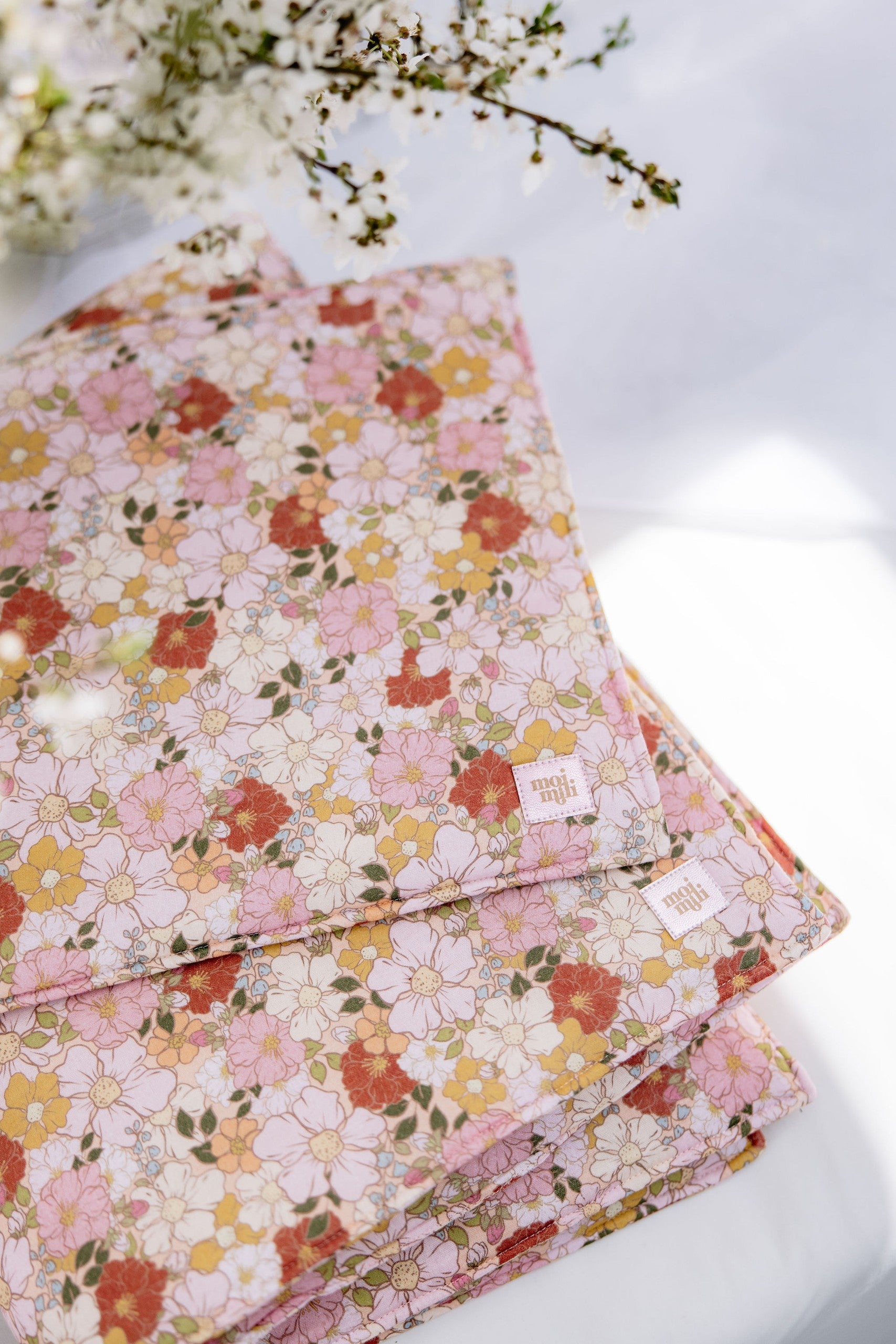 elegant spring garden muslin baby pillow and blanket set on a neutral background