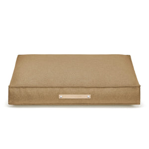 bold møvik dog cushion in biscuit on a dark slate floor, showcasing its modern design