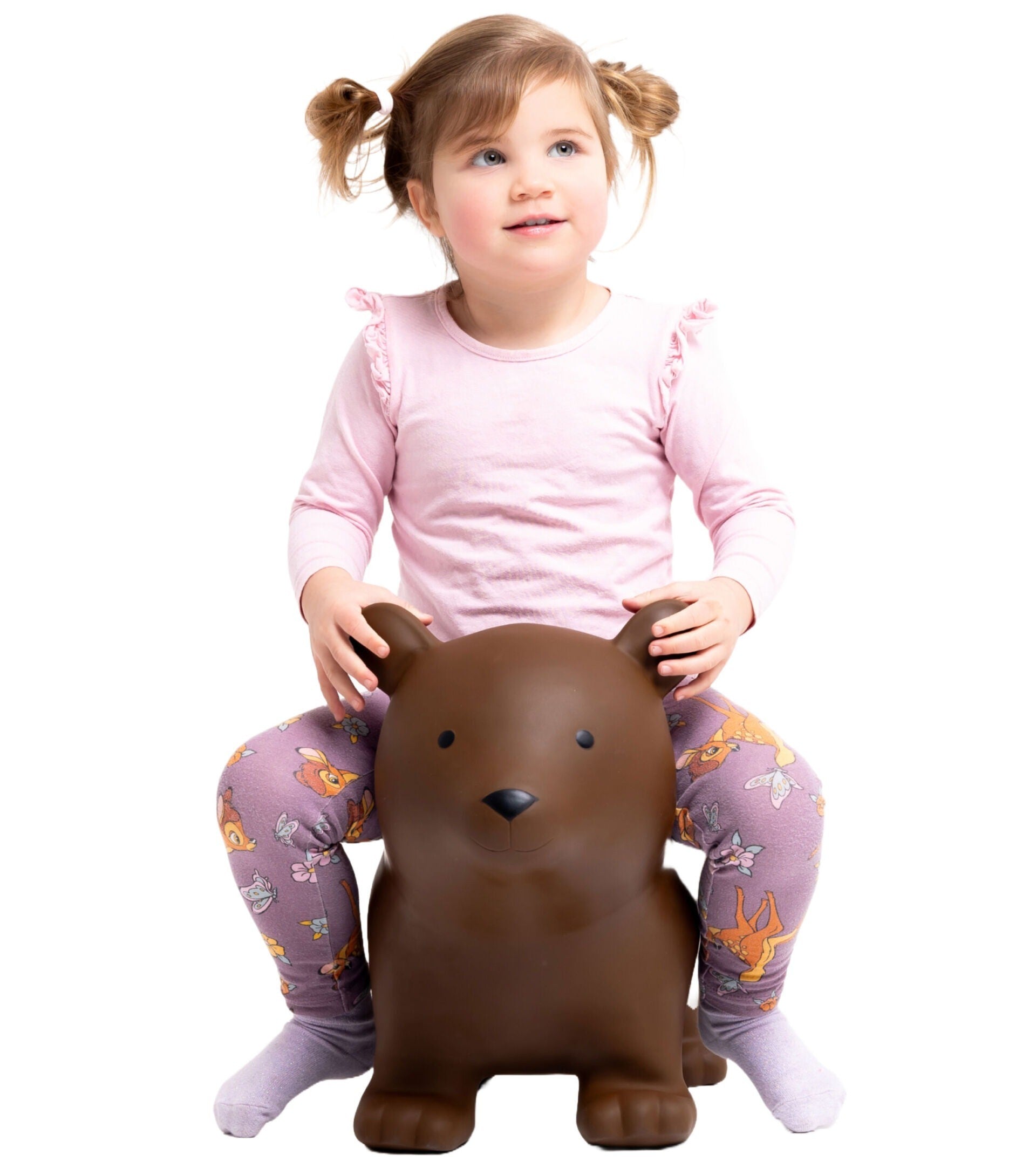 playful brown bear jumpy toy bouncing in a sunlit garden with a laughing toddler