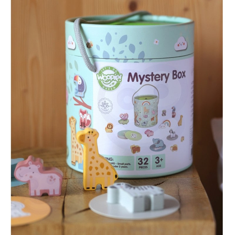 a child's hand gently feeling for a wooden heart shape inside the soft fabric mystery box