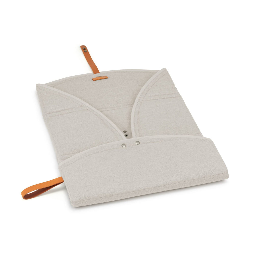 elegant beige okka travel mat with a luxurious leather belt detail, laid out on a polished floor