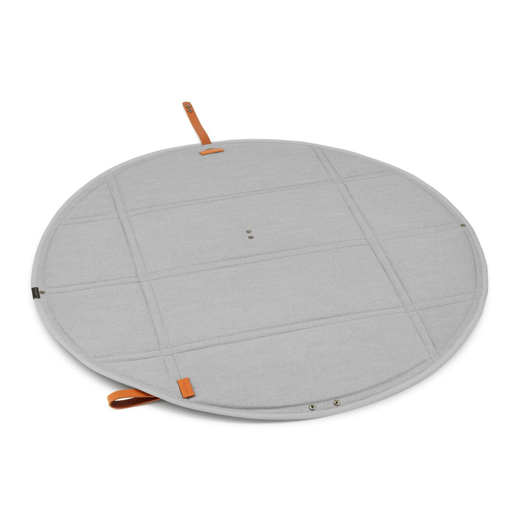 a playful dog resting on the stylish grey okka travel mat during a sunny park adventure