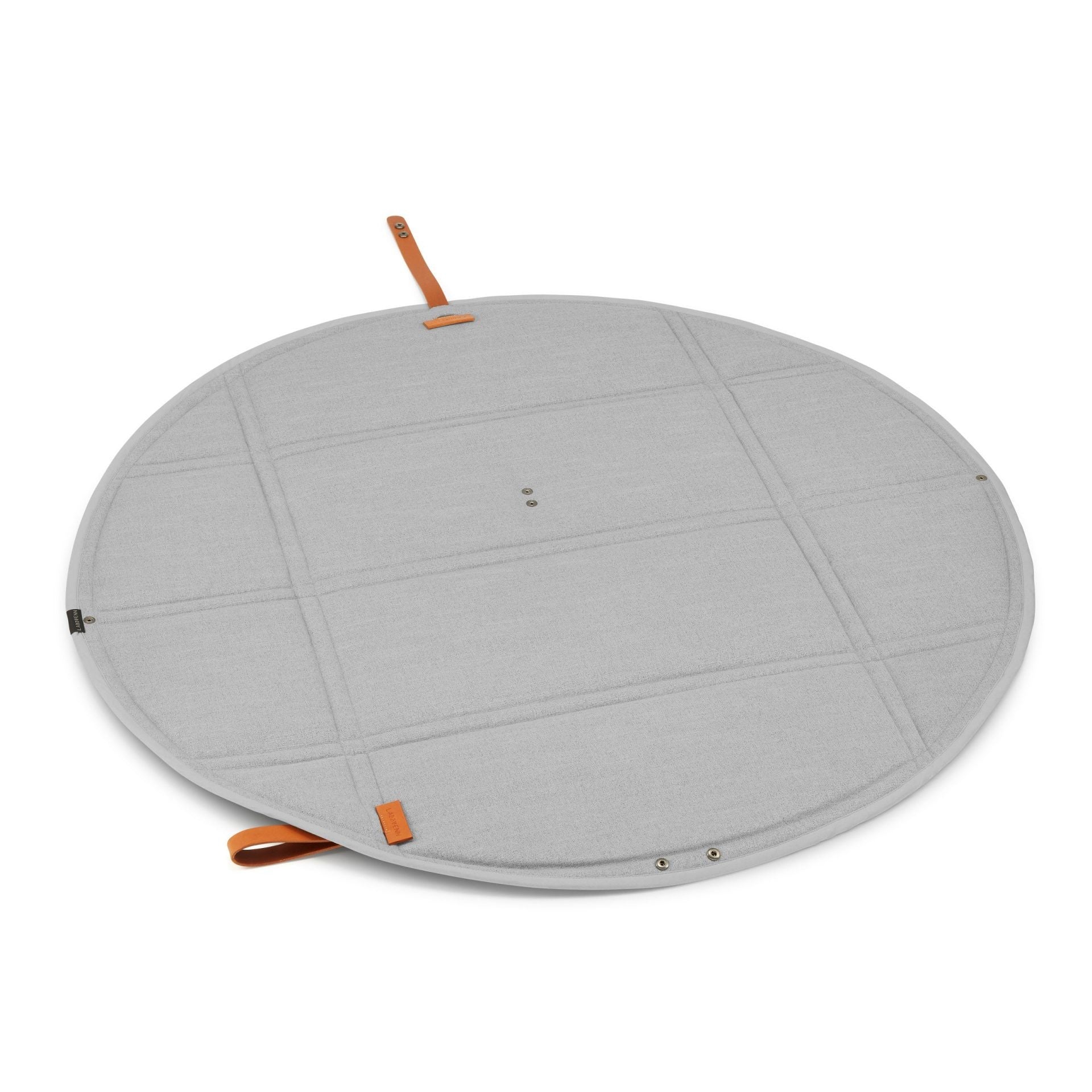 a playful dog resting on the stylish grey okka travel mat during a sunny park adventure