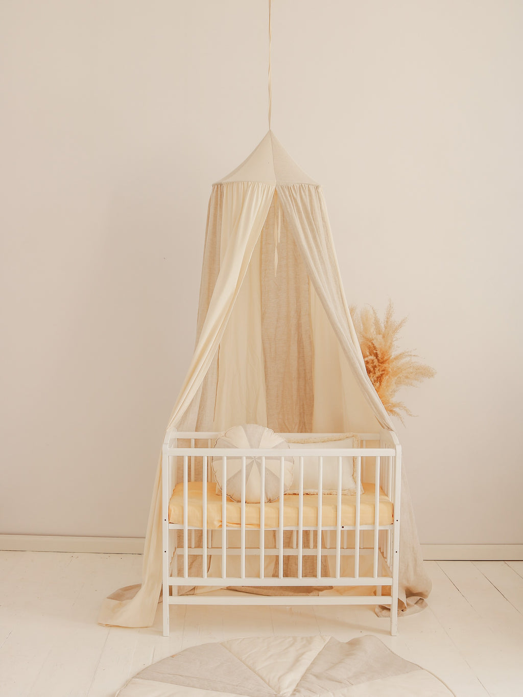 cream and grey organic cotton linen canopy hanging over a cozy reading nook with soft natural light